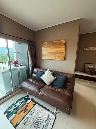 Cozy living room with leather sofa and balcony view, perfect for relaxation.