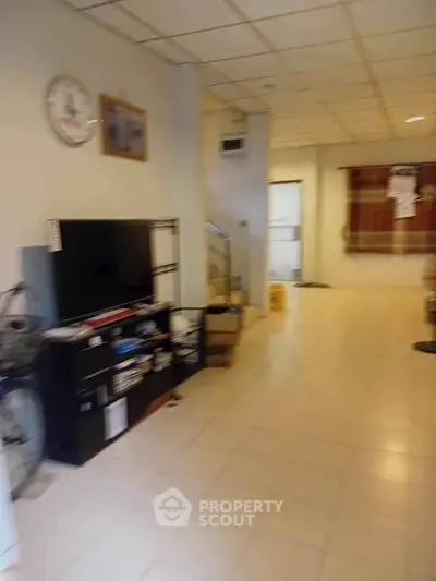 Spacious living room with tiled flooring and modern TV setup