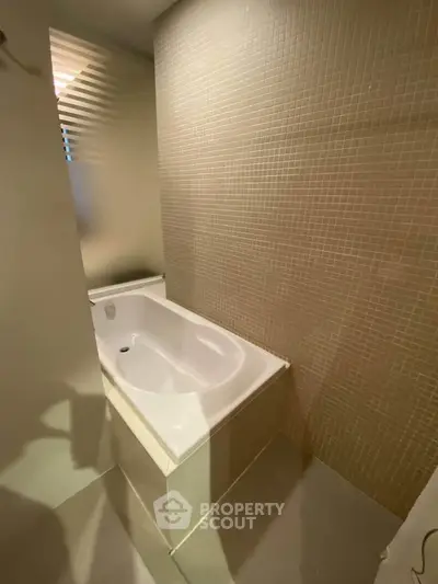 Modern bathroom with sleek bathtub and tiled wall, perfect for relaxation and comfort.