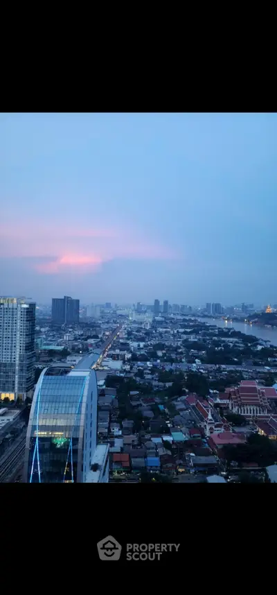 Stunning cityscape view from high-rise building at sunset, showcasing urban skyline and vibrant horizon.