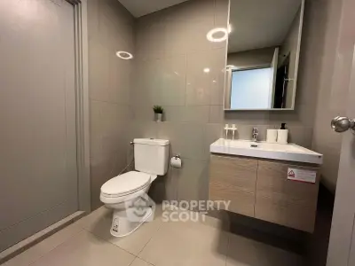 Modern bathroom with sleek fixtures and neutral tones, featuring a stylish vanity and mirror.