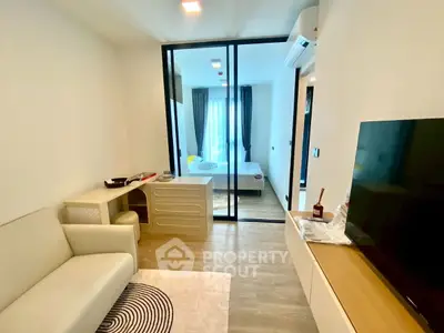 Modern living room with glass partition leading to cozy bedroom
