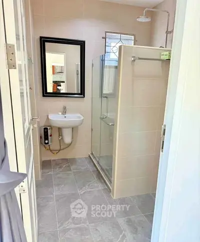 Modern bathroom with glass shower and sleek fixtures in a contemporary home.