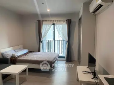 Modern bedroom with balcony access in a stylish apartment, featuring sleek furniture and natural light.