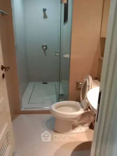 Modern bathroom with glass shower and sleek fixtures in a contemporary apartment.