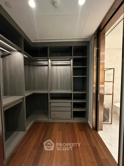 Luxurious walk-in closet with wooden flooring and ample storage space