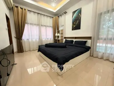 Spacious bedroom with modern decor and large windows for natural light