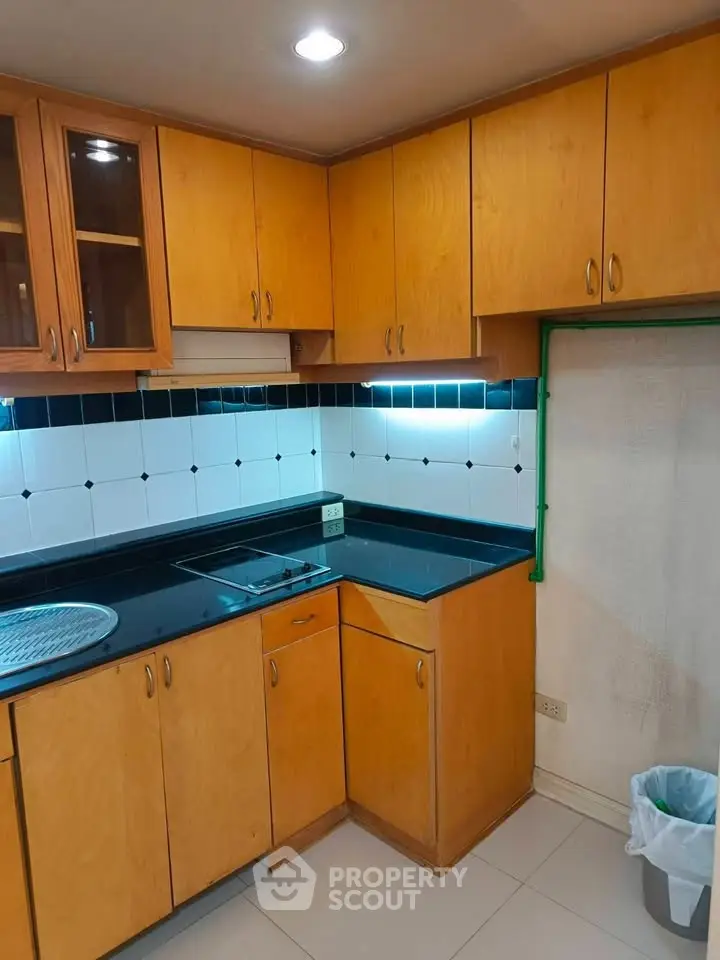Cozy kitchen with wooden cabinets and modern black countertops