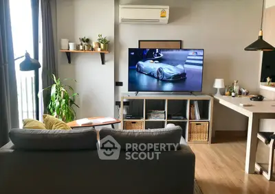 Modern living room with sleek furniture and large TV, perfect for relaxation and entertainment.