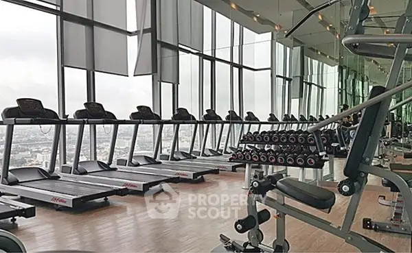 Luxurious high-rise gym with panoramic city views and modern fitness equipment.