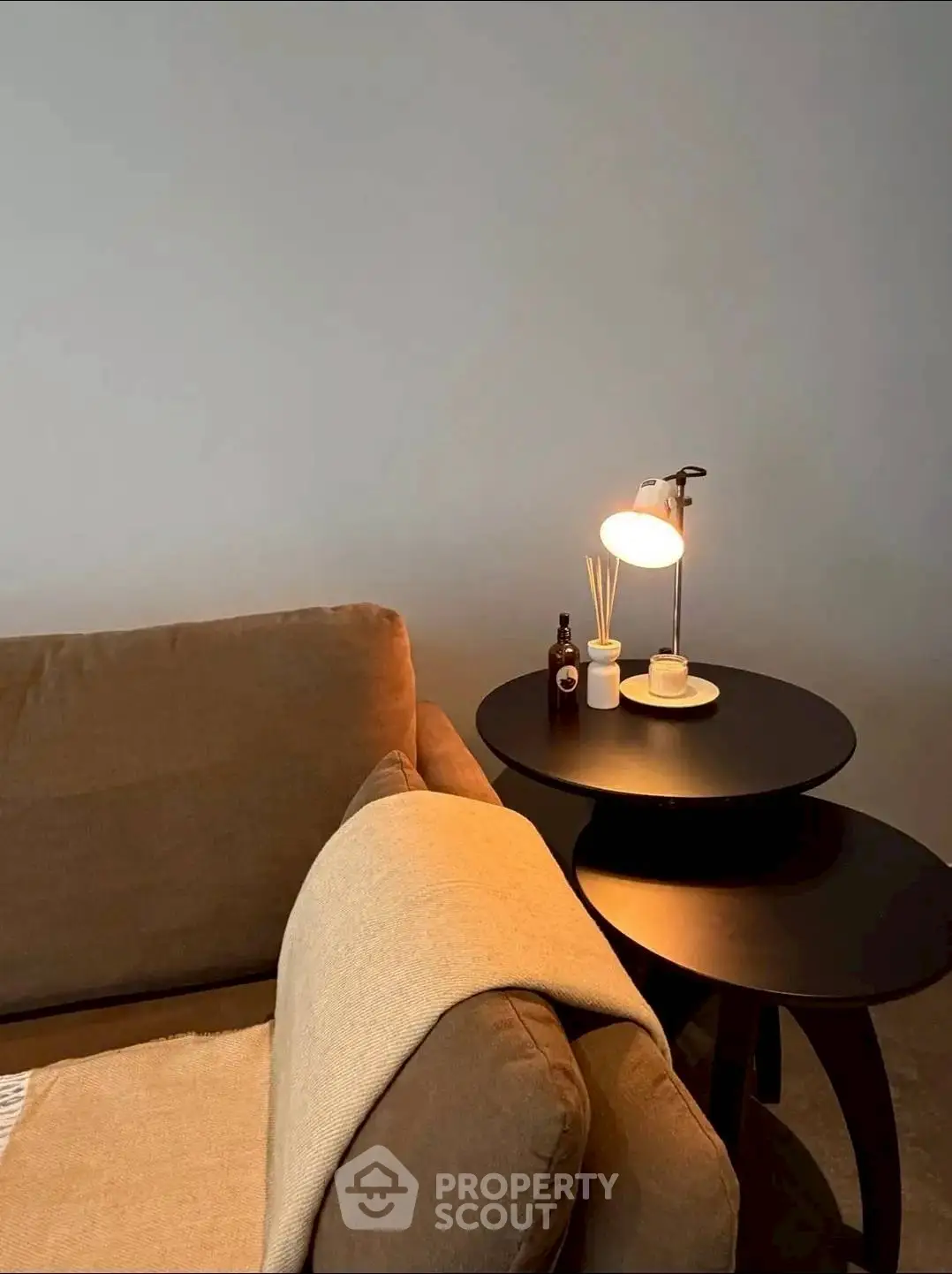 Cozy living room corner with stylish brown sofa and modern side table lamp.