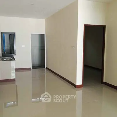 Spacious interior with glossy tiled flooring and modern kitchen area.