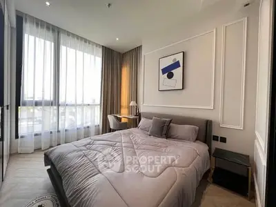 Modern bedroom with large windows and stylish decor in a luxury apartment.