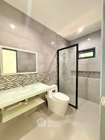 Modern bathroom with sleek design, glass shower, and stylish tile accents.