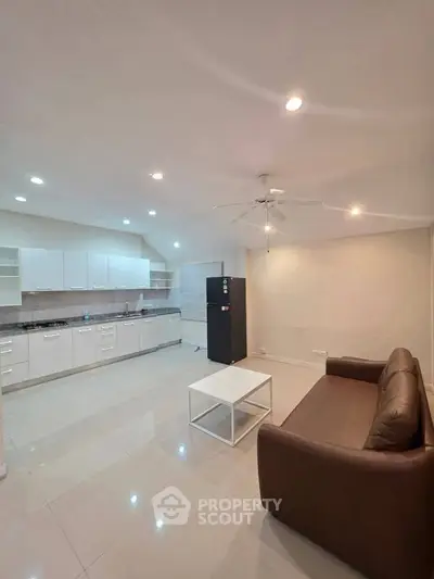 Spacious open-plan living room with modern kitchen and cozy seating area.
