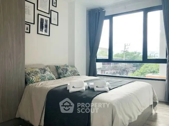 Bright and cozy bedroom with large window and stylish decor