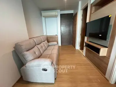 Modern living room with cozy sofa and wall-mounted TV in stylish apartment.