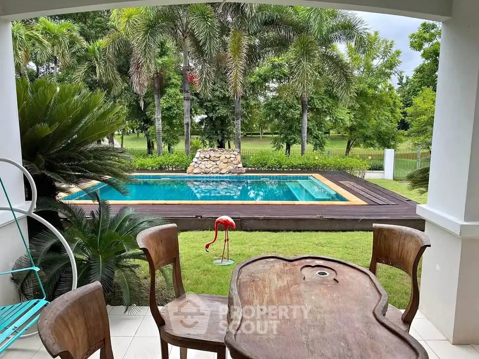 Charming outdoor view with pool and lush greenery from a cozy patio.