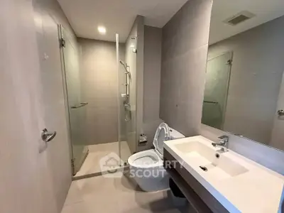 Modern bathroom with glass shower and sleek fixtures in a contemporary apartment.