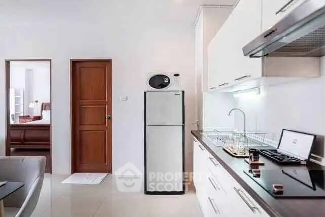 Modern kitchen with sleek cabinetry and stainless steel appliances in a bright apartment.