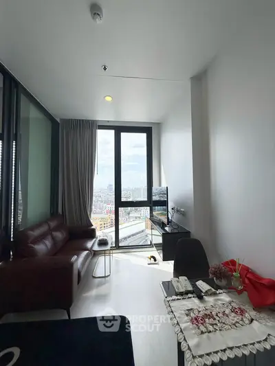 Modern living room with city view, featuring sleek furniture and large windows for natural light.
