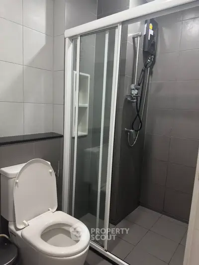 Modern bathroom with sleek shower and toilet in a compact layout.