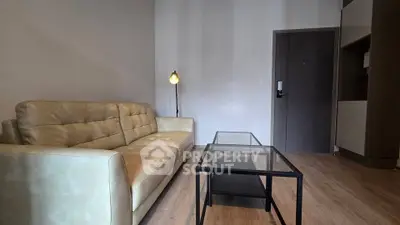 Modern living room with stylish sofa and glass coffee table in a cozy apartment.