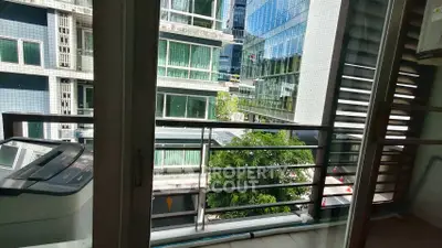 Modern apartment balcony with city view and nearby buildings.