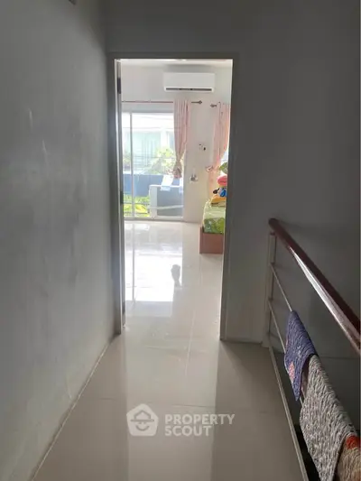 Bright hallway leading to a cozy bedroom with garden view, perfect for relaxation.