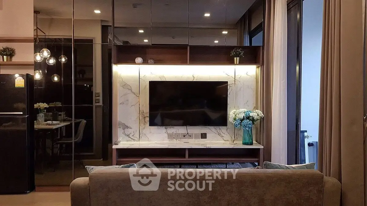 Modern living room with elegant decor and large TV on marble wall