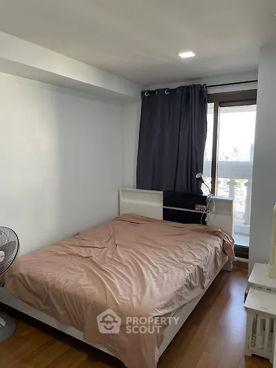 Cozy bedroom with city view, featuring a comfortable bed and modern decor, perfect for urban living.