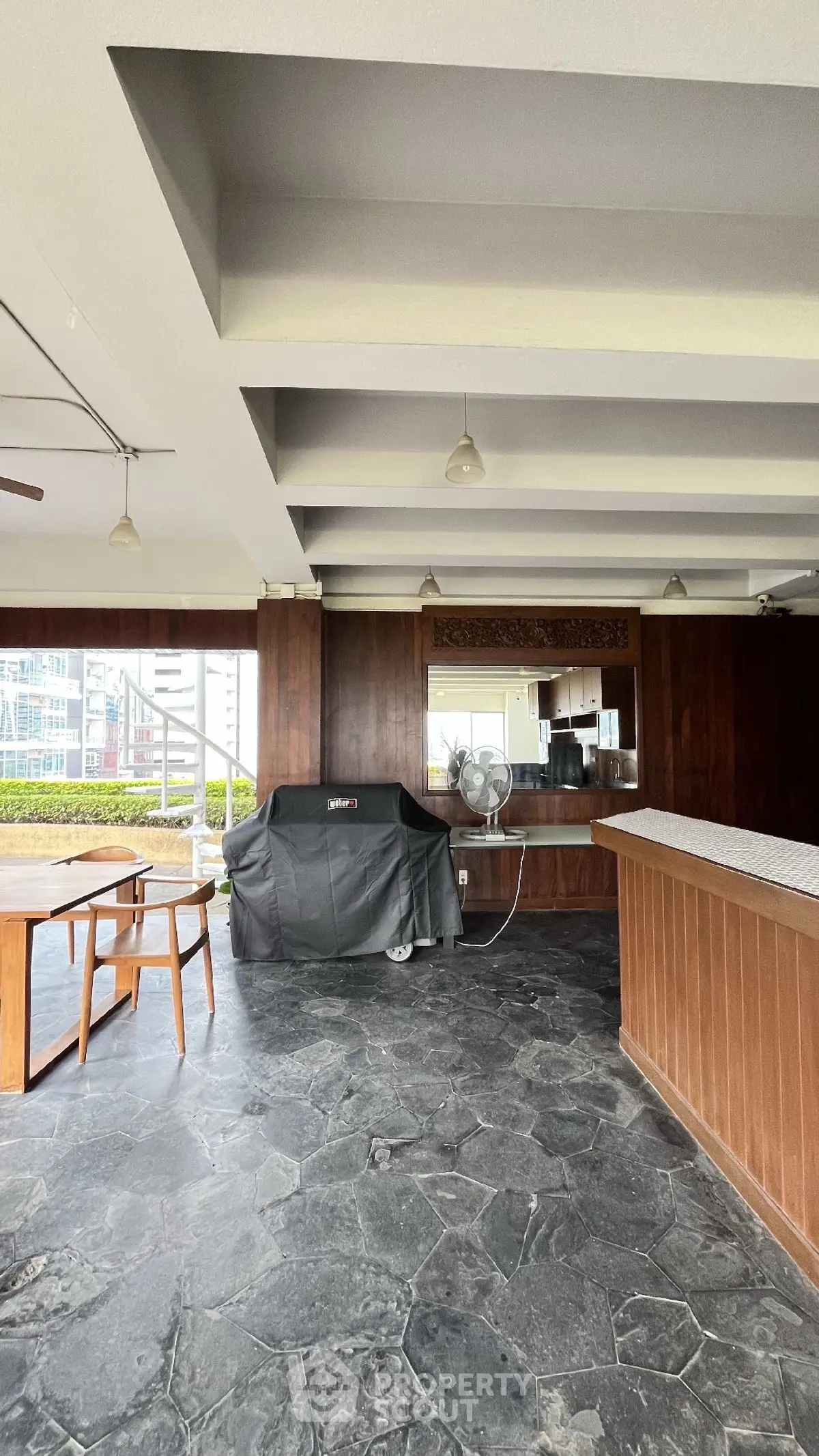 Spacious outdoor BBQ area with modern grill and seating, perfect for entertaining.