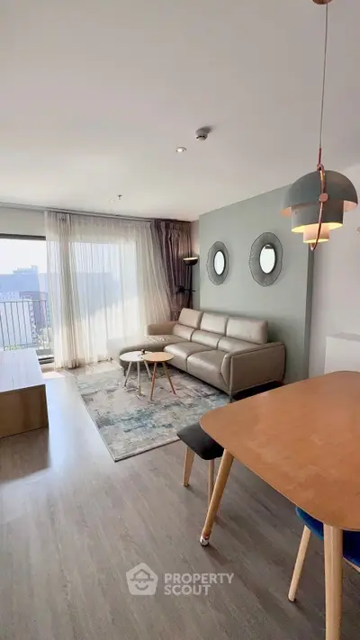 Modern living room with stylish decor and city view, featuring a cozy sofa and elegant lighting.