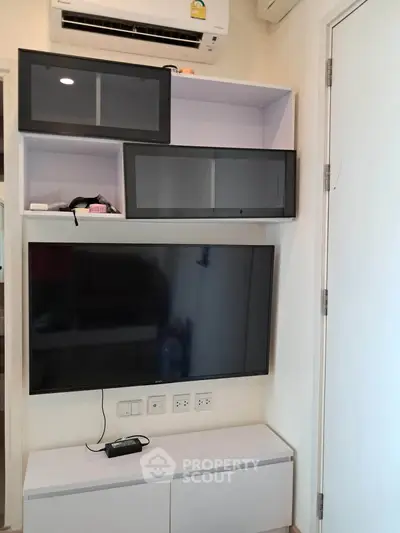 Modern living room with wall-mounted TV and sleek storage cabinets
