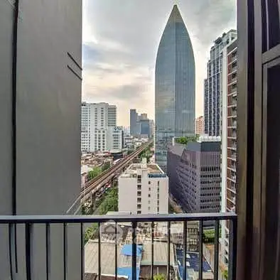 Stunning cityscape view from a high-rise balcony overlooking modern skyscrapers.
