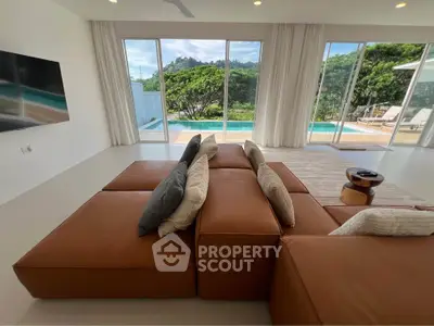 Luxurious living room with pool view and modern brown sofa, perfect for relaxation.