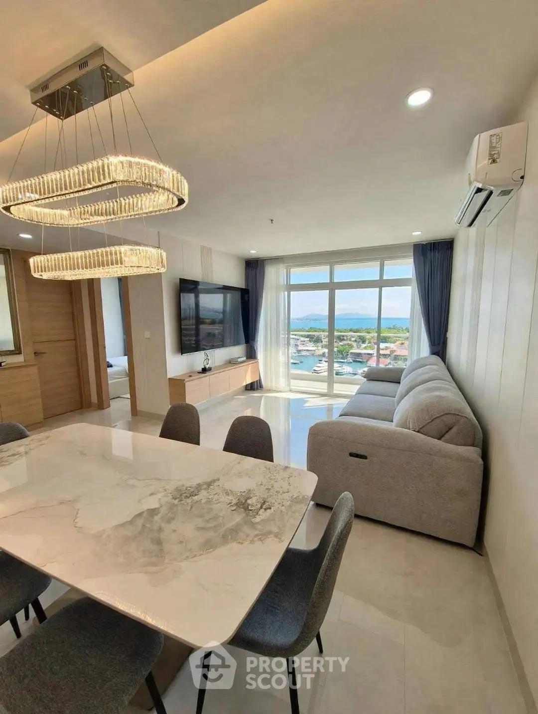 Luxurious modern living room with stunning view, elegant chandelier, and spacious seating area.