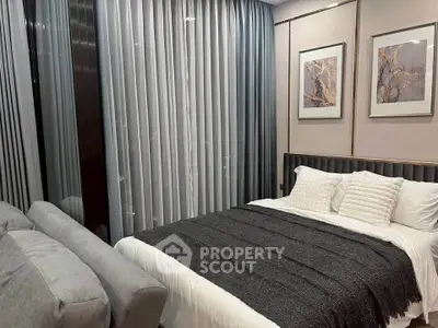 Elegant bedroom with modern decor and cozy ambiance, featuring stylish curtains and framed artwork.