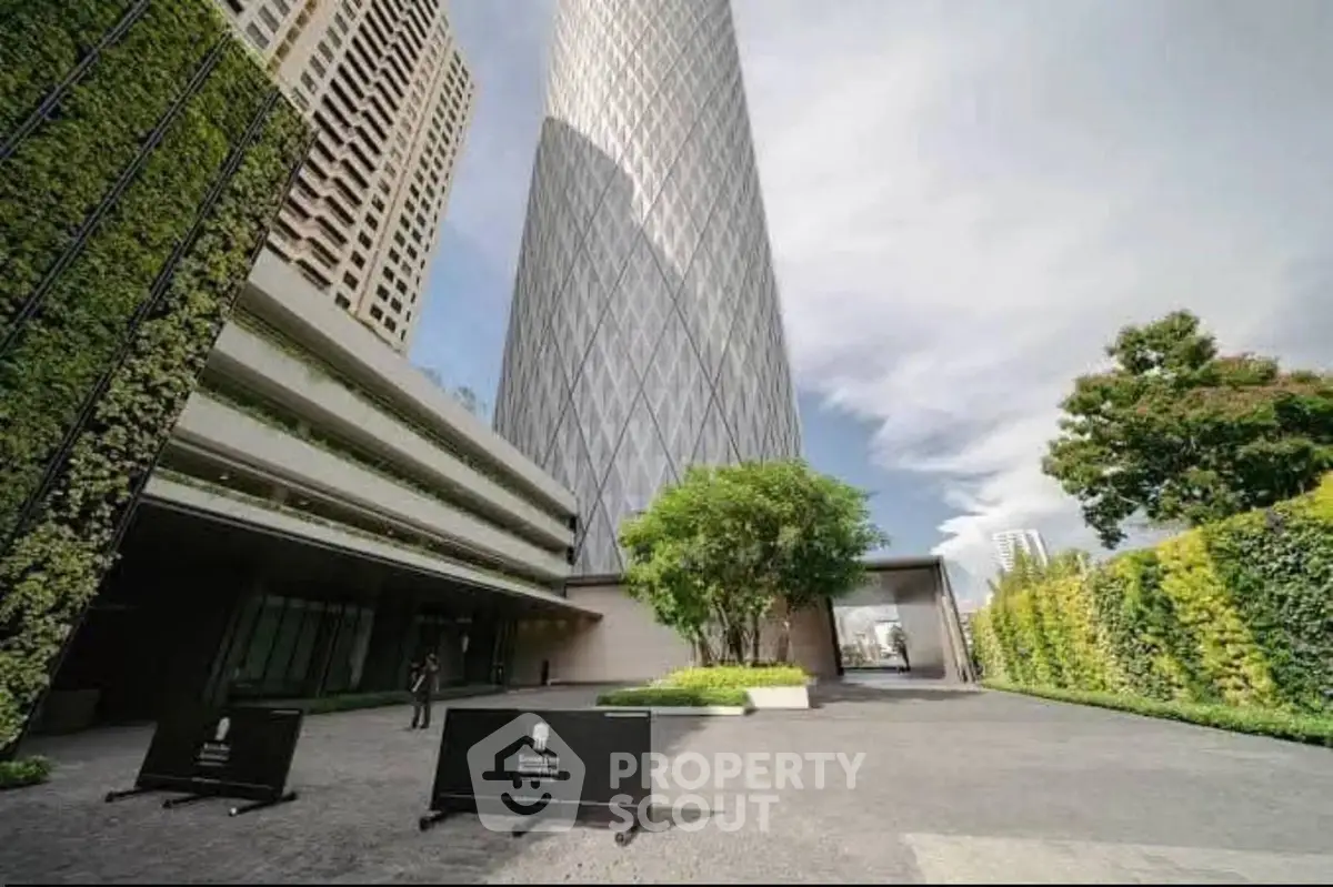 Stunning modern high-rise building with lush green landscaping and spacious entrance.