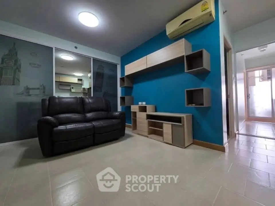 Modern living room with sleek furniture and vibrant blue accent wall