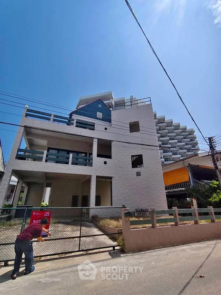 Modern multi-story building with unique architectural design under clear blue sky.