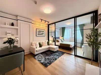 Modern open-plan living room and bedroom with stylish decor and natural light.