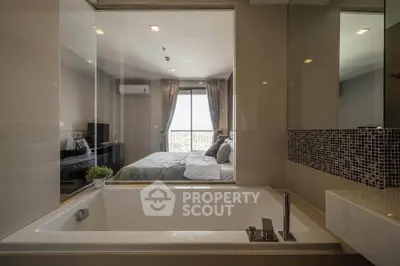 Luxurious bathroom with a view into a stylish bedroom, featuring a modern bathtub and elegant decor.