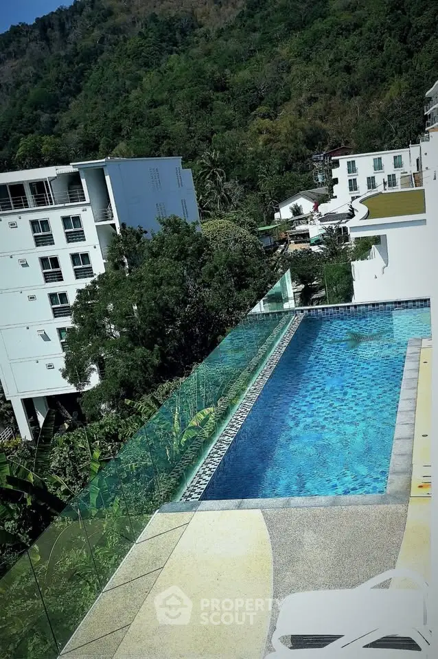 Stunning rooftop pool with scenic mountain views in modern apartment complex.