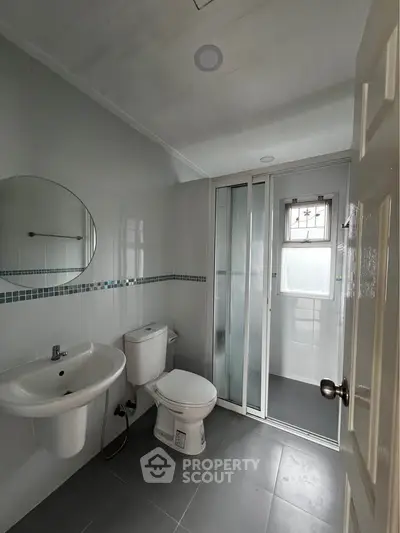 Modern bathroom with sleek design, featuring a shower enclosure and contemporary fixtures.