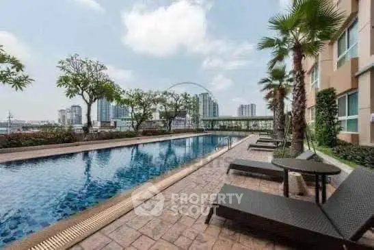 Luxurious condominium pool area with city skyline view, perfect for relaxation and leisure.