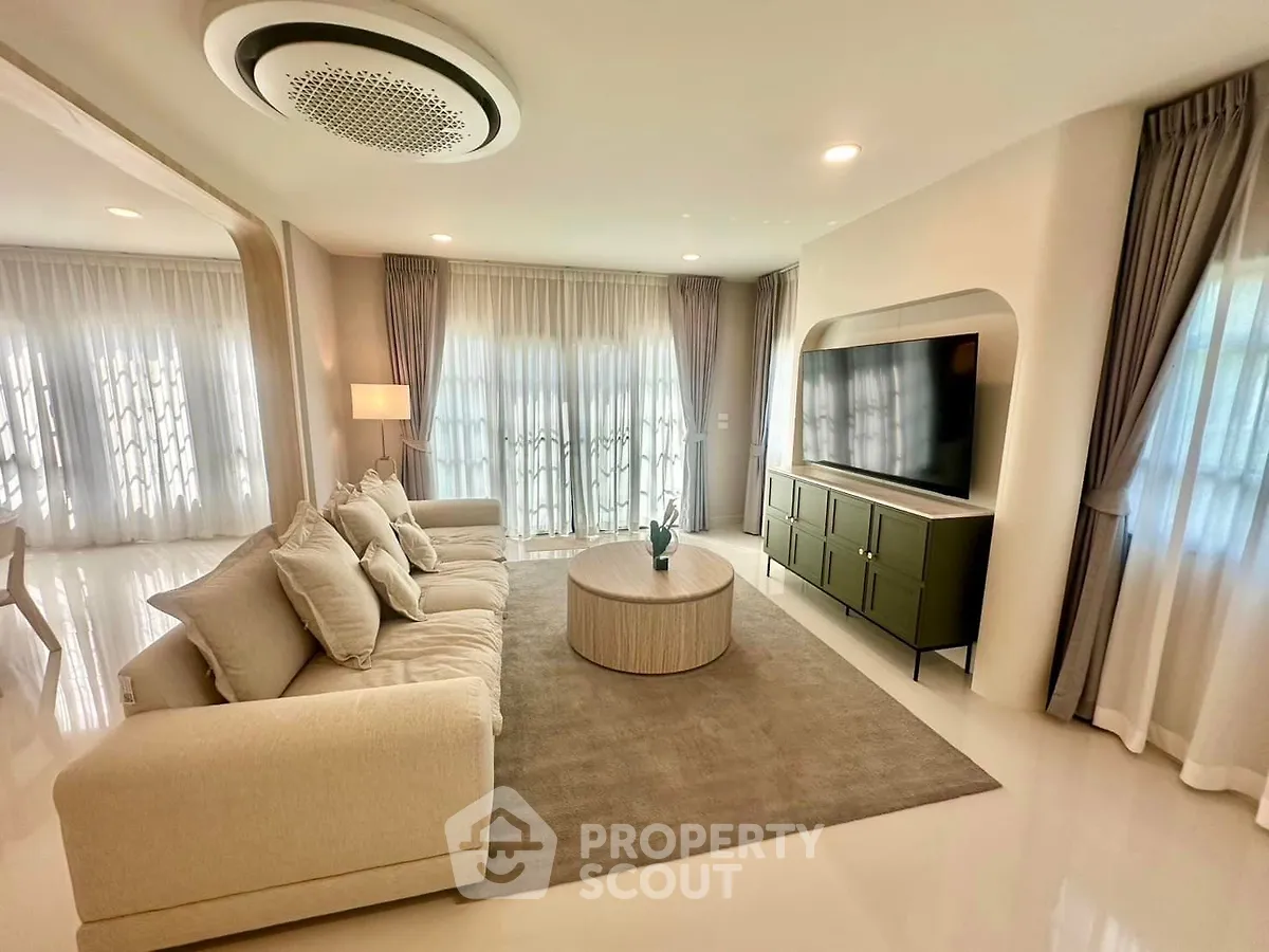 Luxurious living room with modern decor, plush sofa, and large TV, perfect for relaxation and entertainment.