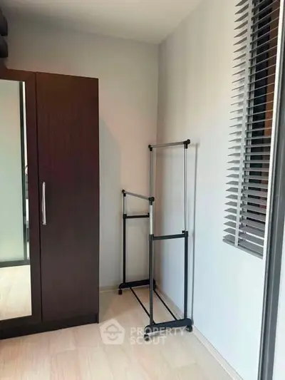 Spacious bedroom corner with wardrobe and clothes rack, perfect for organizing your fashion essentials.