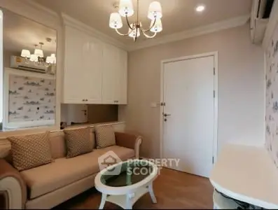 Charming living room with elegant chandelier and cozy sofa in modern apartment.
