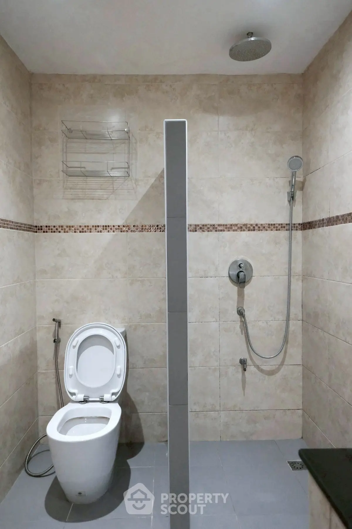 Modern bathroom with shower and toilet in a tiled setting